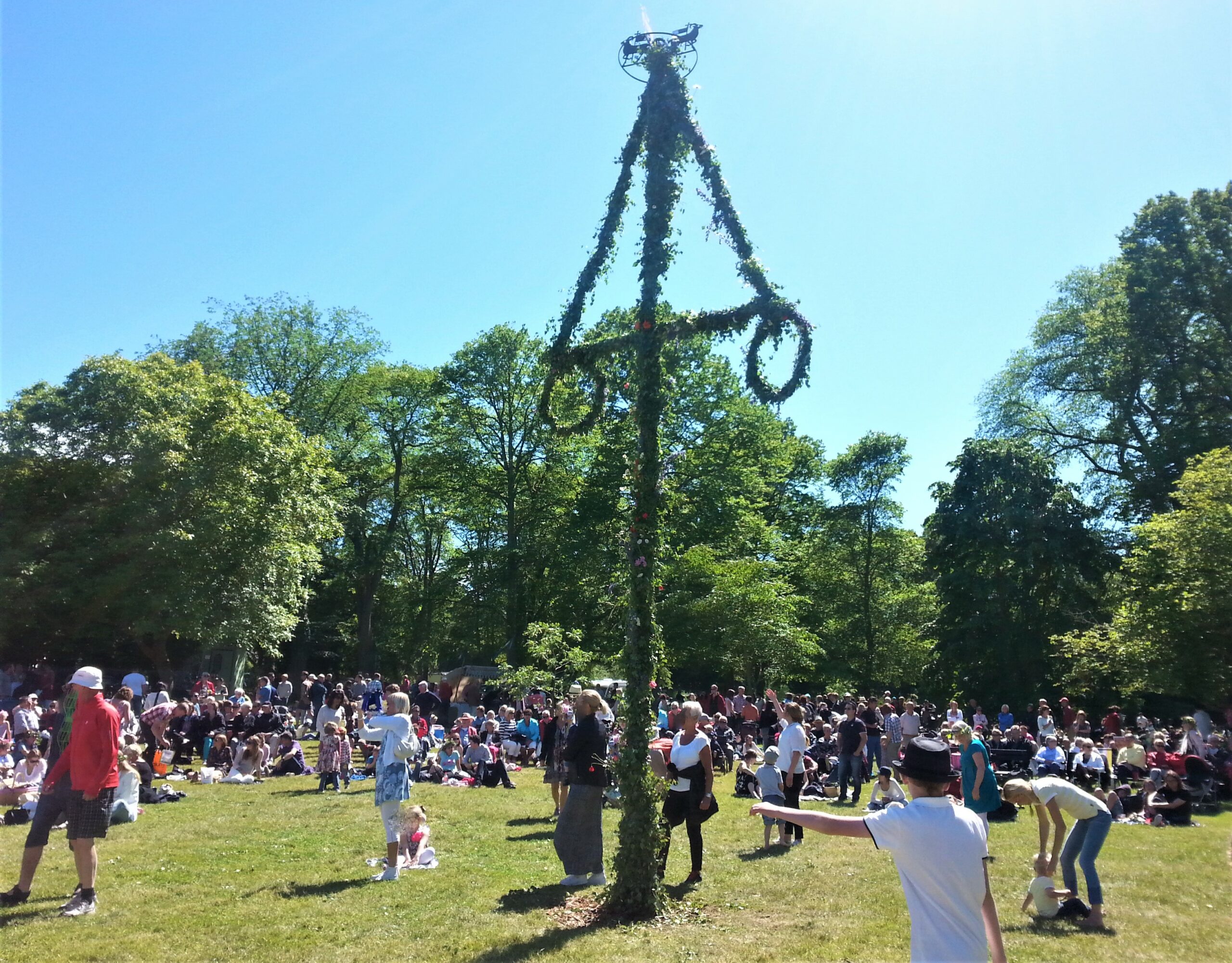 Midsommarstång och många människor vid Paviljongsplan i VIsby