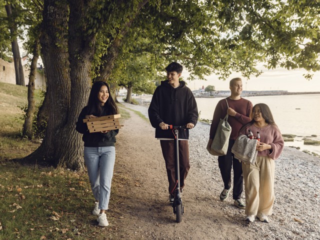 Fyra ungdomar promenerar på Strandpromenaden i Visby